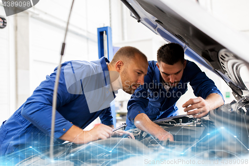 Image of mechanic men with wrench repairing car at workshop