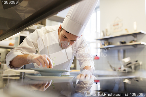 Image of happy male chef cooking food at restaurant kitchen