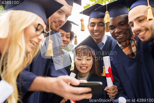 Image of students or graduates with diplomas and smartphone