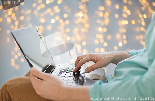 Image of close up of man typing on laptop keyboard