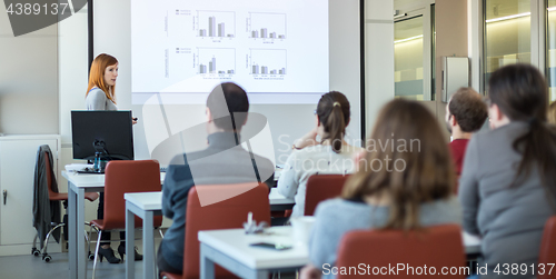 Image of Woman giving presentation in lecture hall at university.