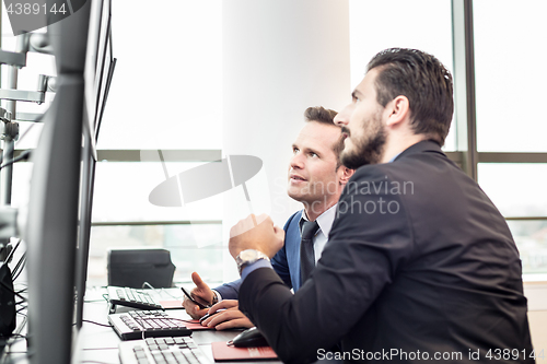 Image of Stock traders looking at market data on computer screens.