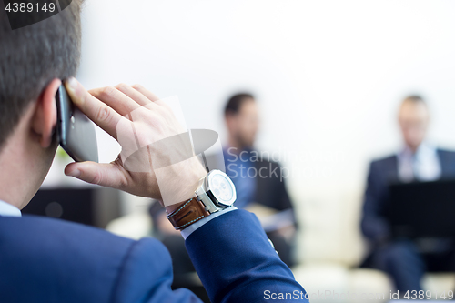 Image of Corporate business team at business meeting and manager talking on phone.