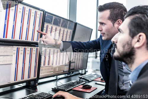 Image of Stock traders looking at market data on computer screens.