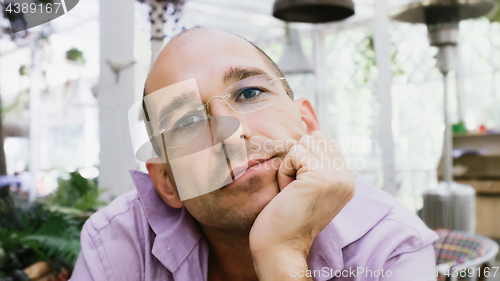 Image of Pensive Man Wearing Glasses Sitting On A Summer Terrace