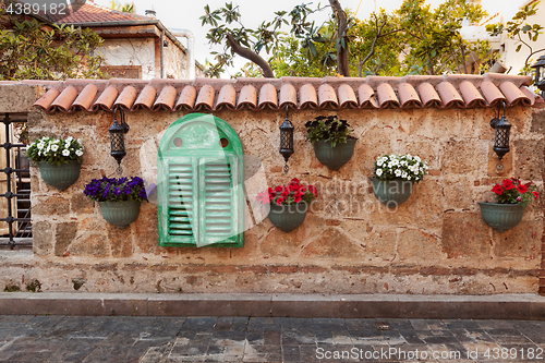 Image of Old stonewall decorated with flowers