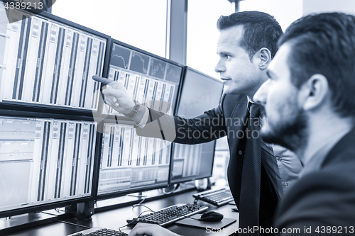 Image of Stock traders looking at market data on computer screens.