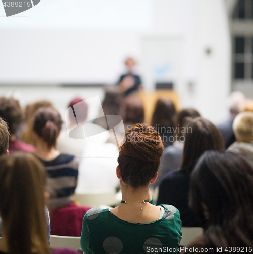 Image of Woman giving presentation in lecture hall at university.