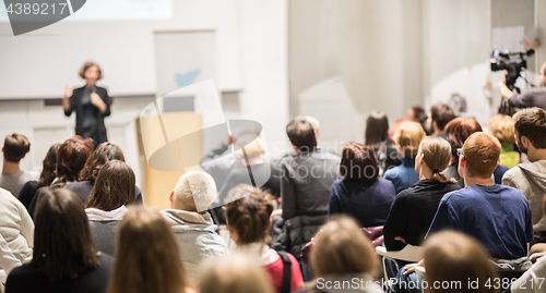 Image of Woman giving presentation in lecture hall at university.