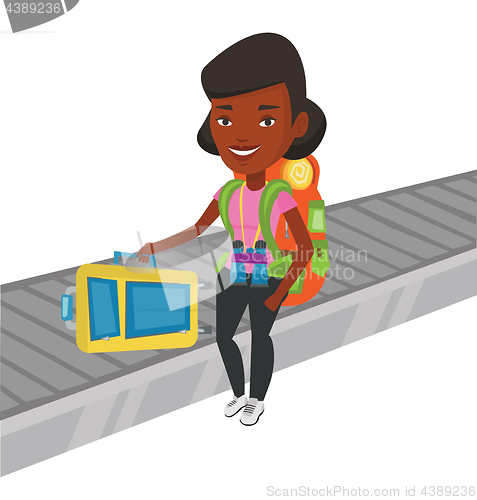 Image of Woman picking up suitcase on luggage conveyor belt