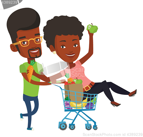 Image of Couple of friends riding by shopping trolley.