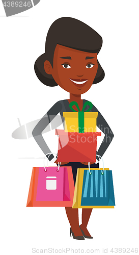 Image of Happy woman holding shopping bags and gift boxes.