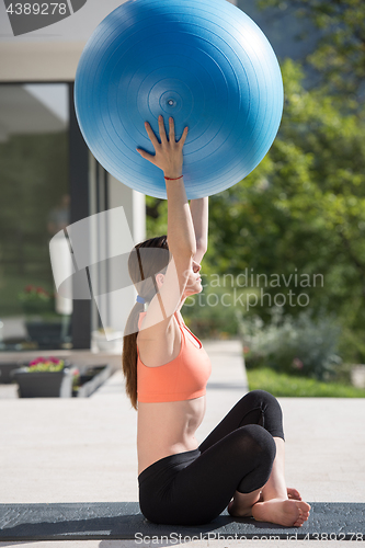 Image of woman doing exercise with pilates ball