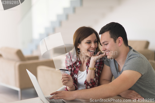 Image of happy young couple buying online