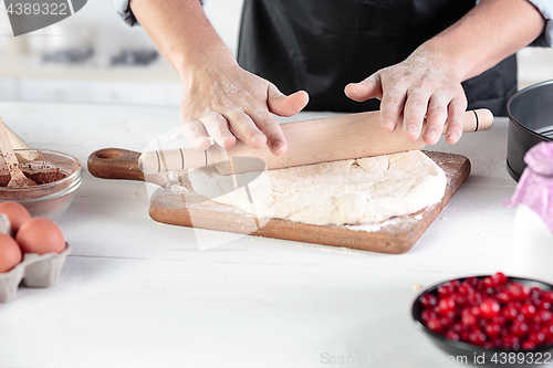 Image of A cook with eggs on a rustic kitchen against the background of men\'s hands