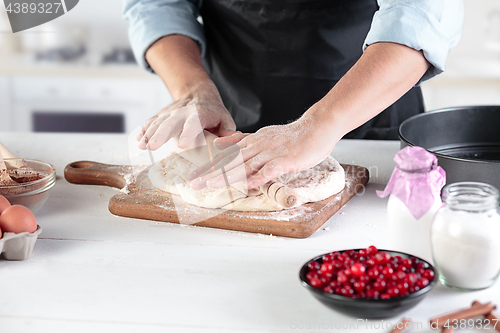 Image of A cook with eggs on a rustic kitchen against the background of men\'s hands