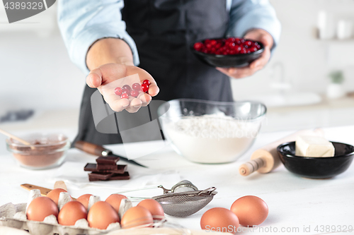 Image of A cook with eggs on a rustic kitchen against the background of men\'s hands