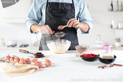 Image of A cook with eggs on a rustic kitchen against the background of men\'s hands