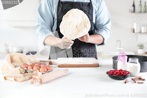 Image of A cook with eggs on a rustic kitchen against the background of men\'s hands