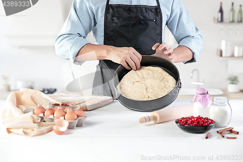 Image of A cook with eggs on a rustic kitchen against the background of men\'s hands