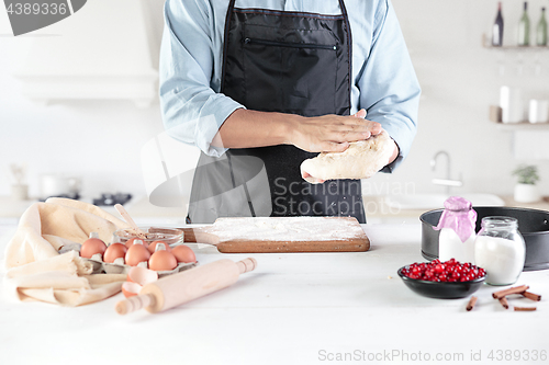 Image of A cook with eggs on a rustic kitchen against the background of men\'s hands