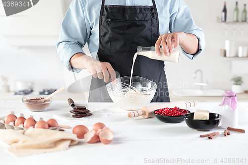 Image of A cook with eggs on a rustic kitchen against the background of men\'s hands