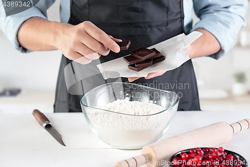 Image of A cook with eggs on a rustic kitchen against the background of men\'s hands