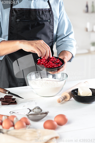 Image of A cook with eggs on a rustic kitchen against the background of men\'s hands