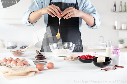 Image of A cook with eggs on a rustic kitchen against the background of men\'s hands