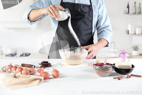 Image of A cook with eggs on a rustic kitchen against the background of men\'s hands