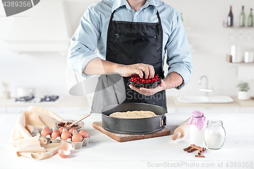 Image of A cook with eggs on a rustic kitchen against the background of men\'s hands