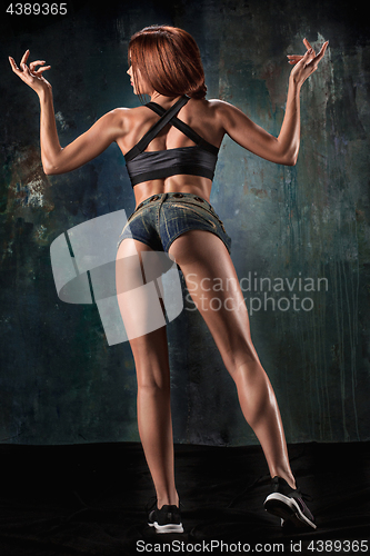 Image of Muscular young woman athlete on black