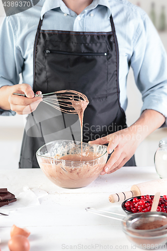 Image of A cook with eggs on a rustic kitchen against the background of men\'s hands