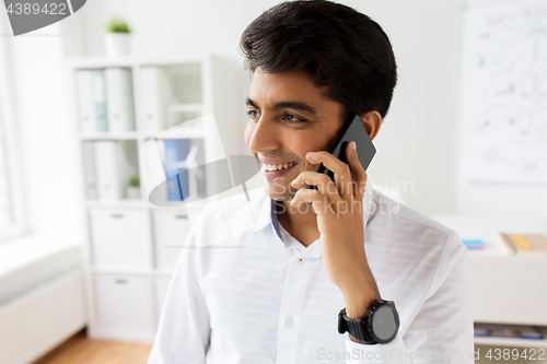 Image of businessman calling on smartphone at office