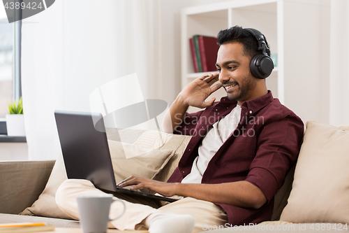 Image of man in headphones with laptop listening to music
