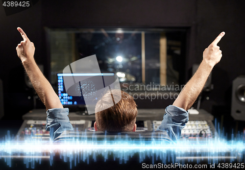 Image of man at mixing console in music recording studio