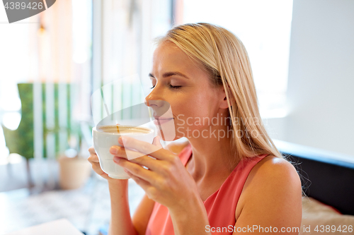 Image of close up of woman drinking coffee at restaurant