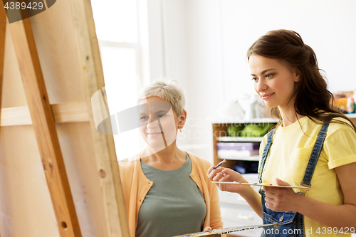 Image of women with brushes painting at art school