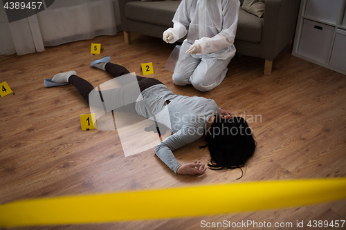 Image of criminalist collecting evidence at crime scene