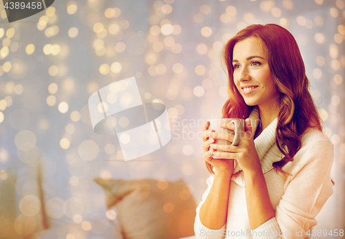 Image of happy woman with cup of tea or coffee at home