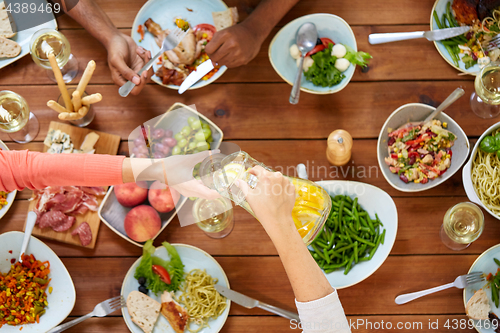 Image of people at table with food eating and drinking