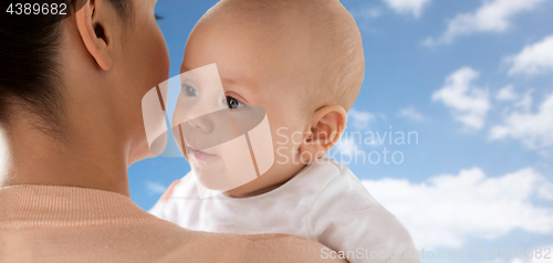 Image of close up of happy little baby with mother over sky