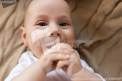 Image of close up of sweet little baby boy lying on blanket