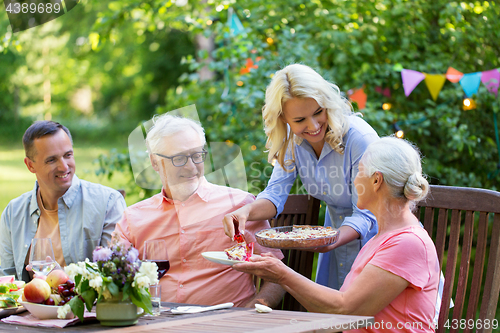 Image of happy family having dinner or summer garden party