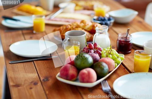 Image of fruits, juice and other food on table at breakfast