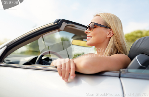 Image of happy young woman in convertible car