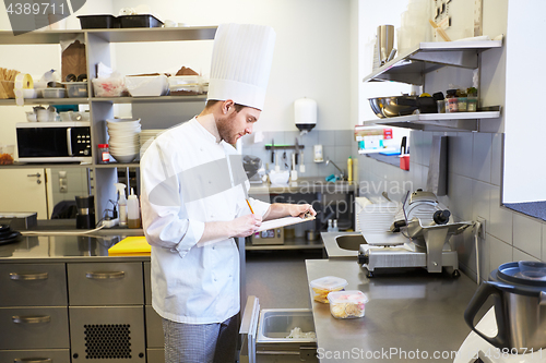 Image of chef with clipboard doing inventory at kitchen