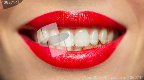 Image of lips or mouth of smiling woman with red lipstick