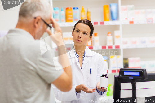 Image of apothecary showing drug to senior man at pharmacy