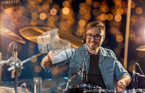 Image of musician or drummer playing drum kit at concert